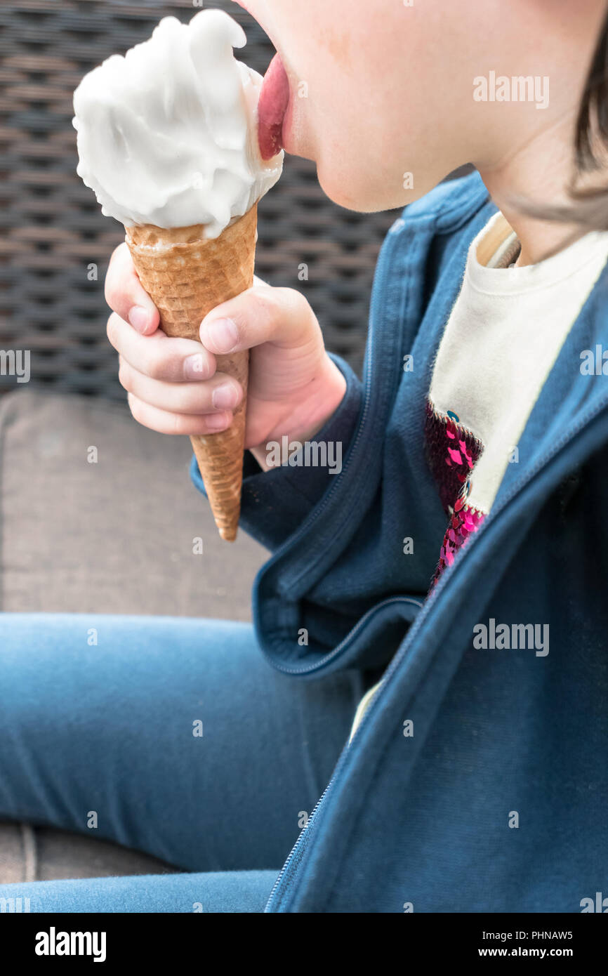 Portrait d'une petite fille qui mange la crème glacée Banque D'Images