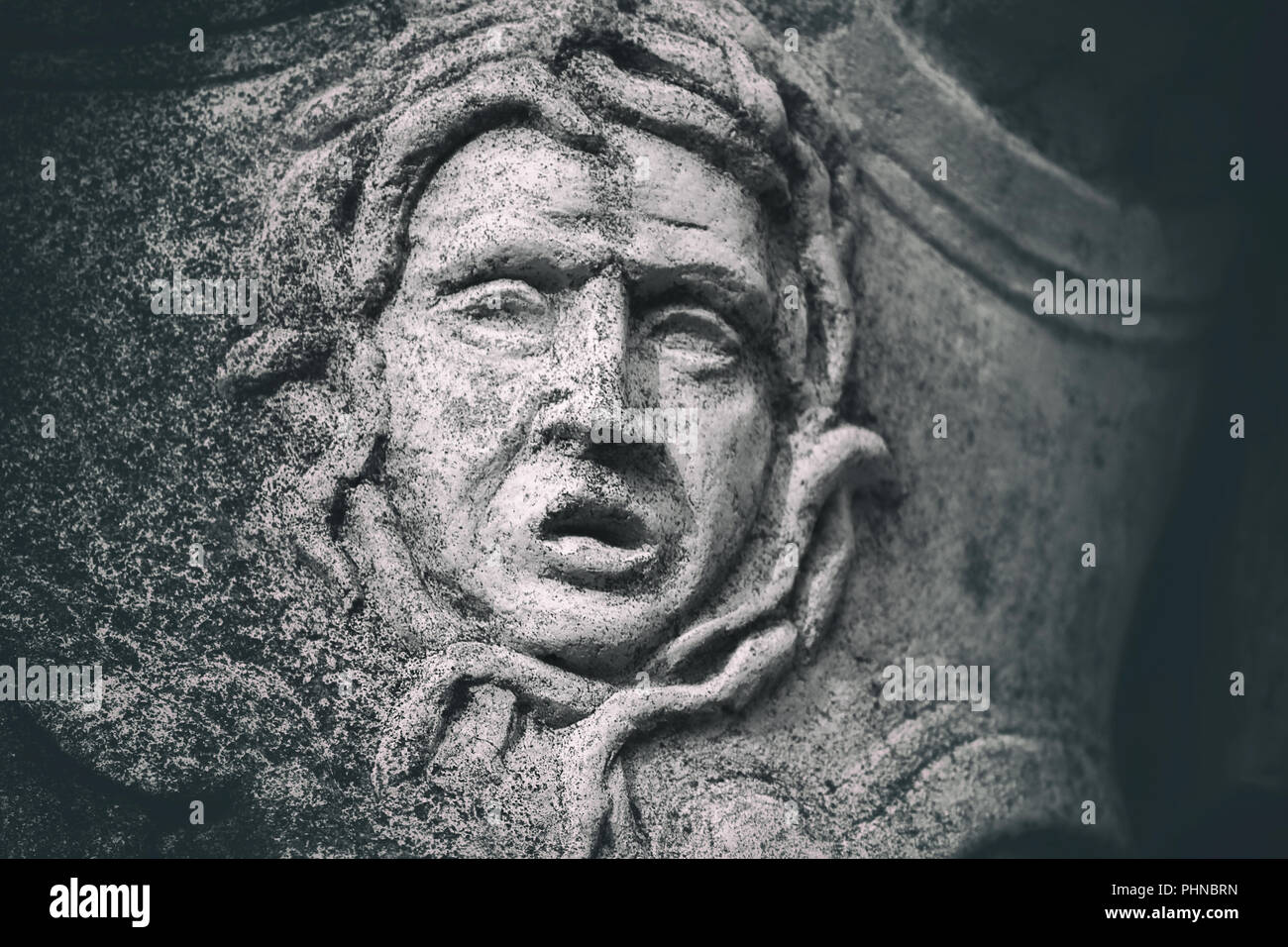 Détail statue gros plan d'une grimace en pierre patiné Banque D'Images