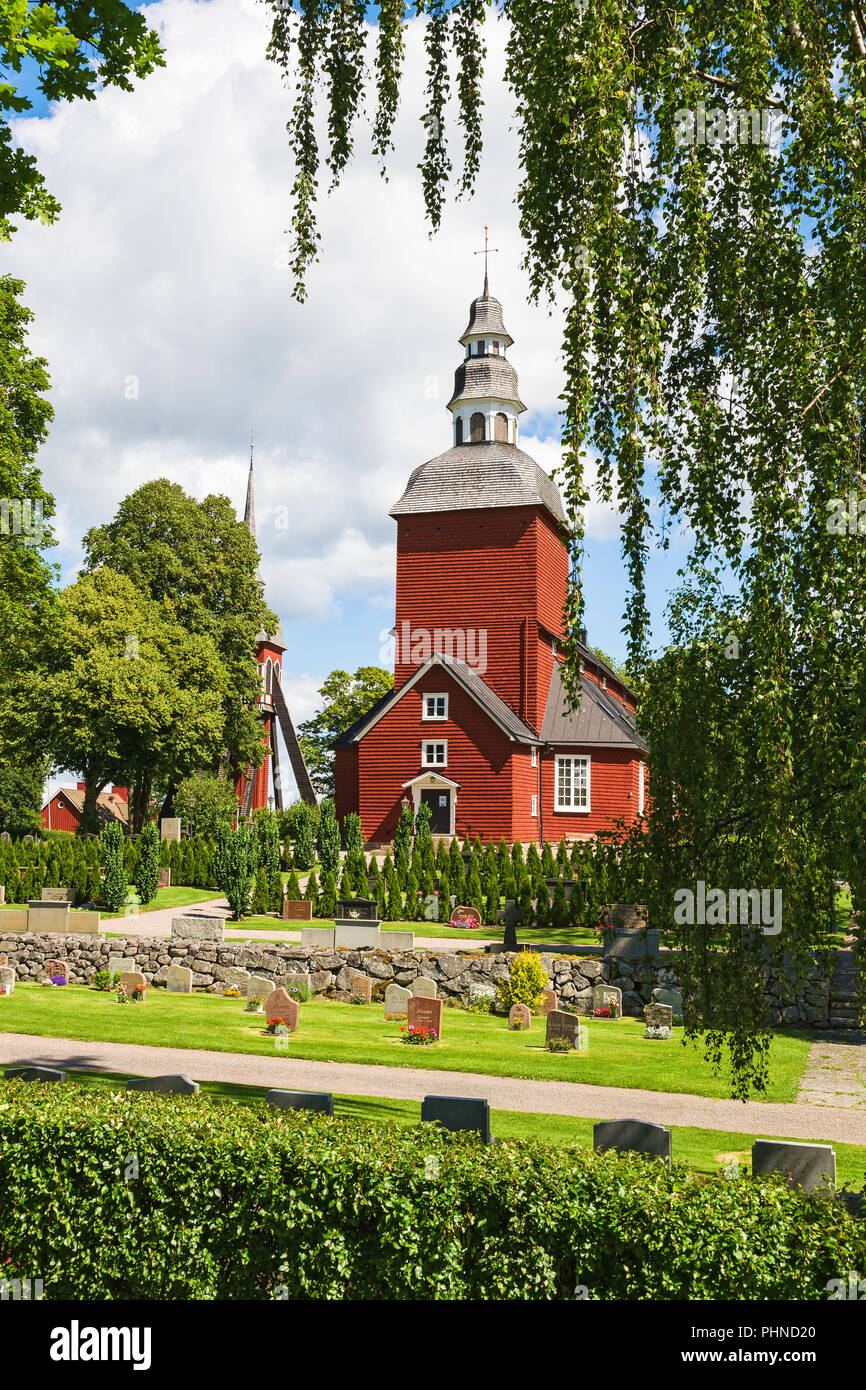 Cimetière avec une église en bois rouge Banque D'Images