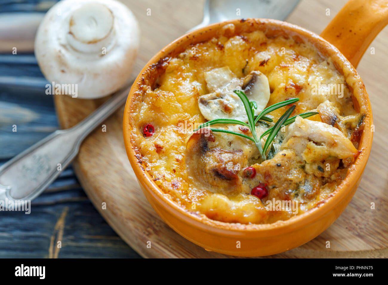 Pot en argile avec champignons sautés, poulet et fromage. Banque D'Images