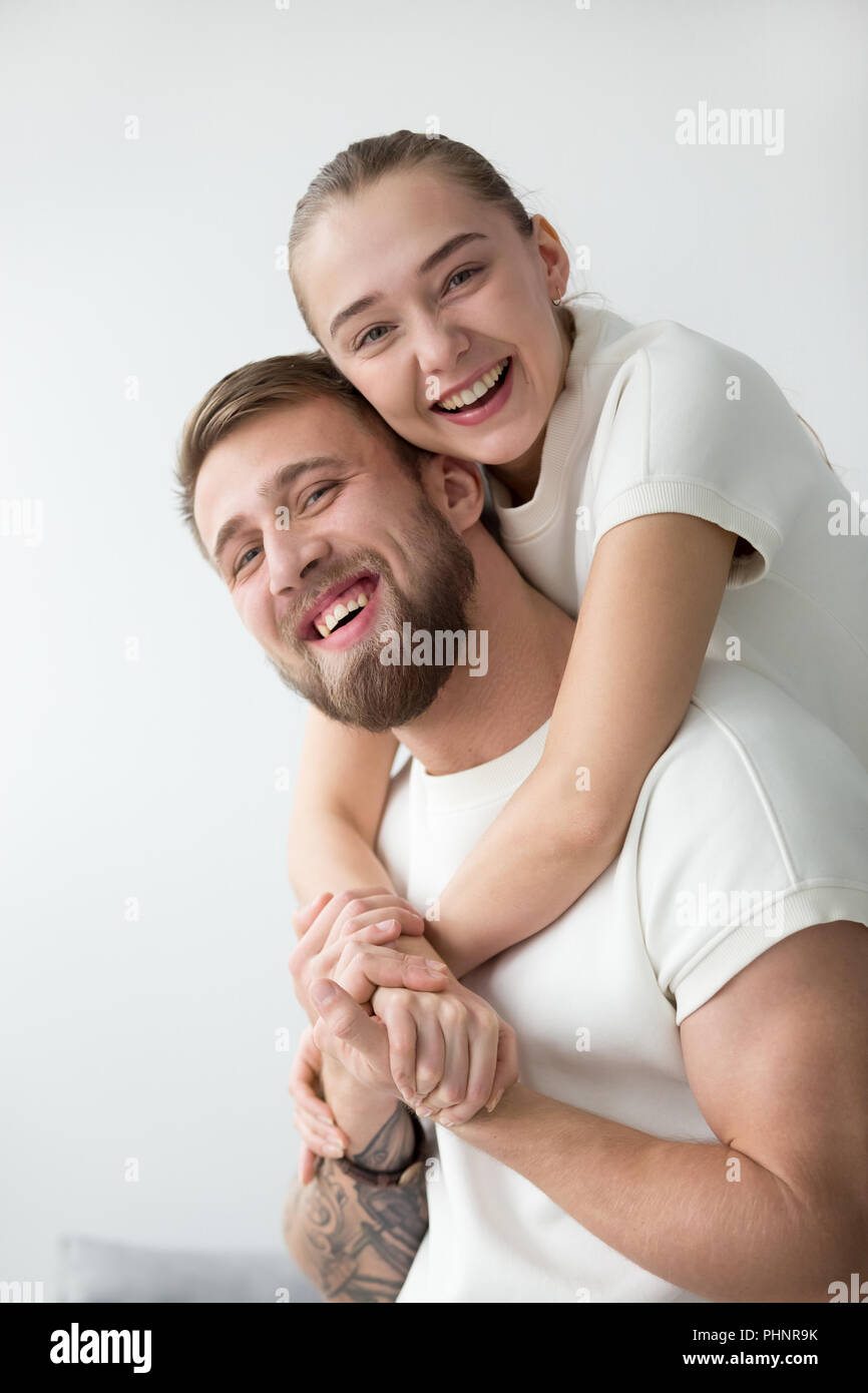 Portrait of smiling girlfriend piggyback mec tatoué Banque D'Images