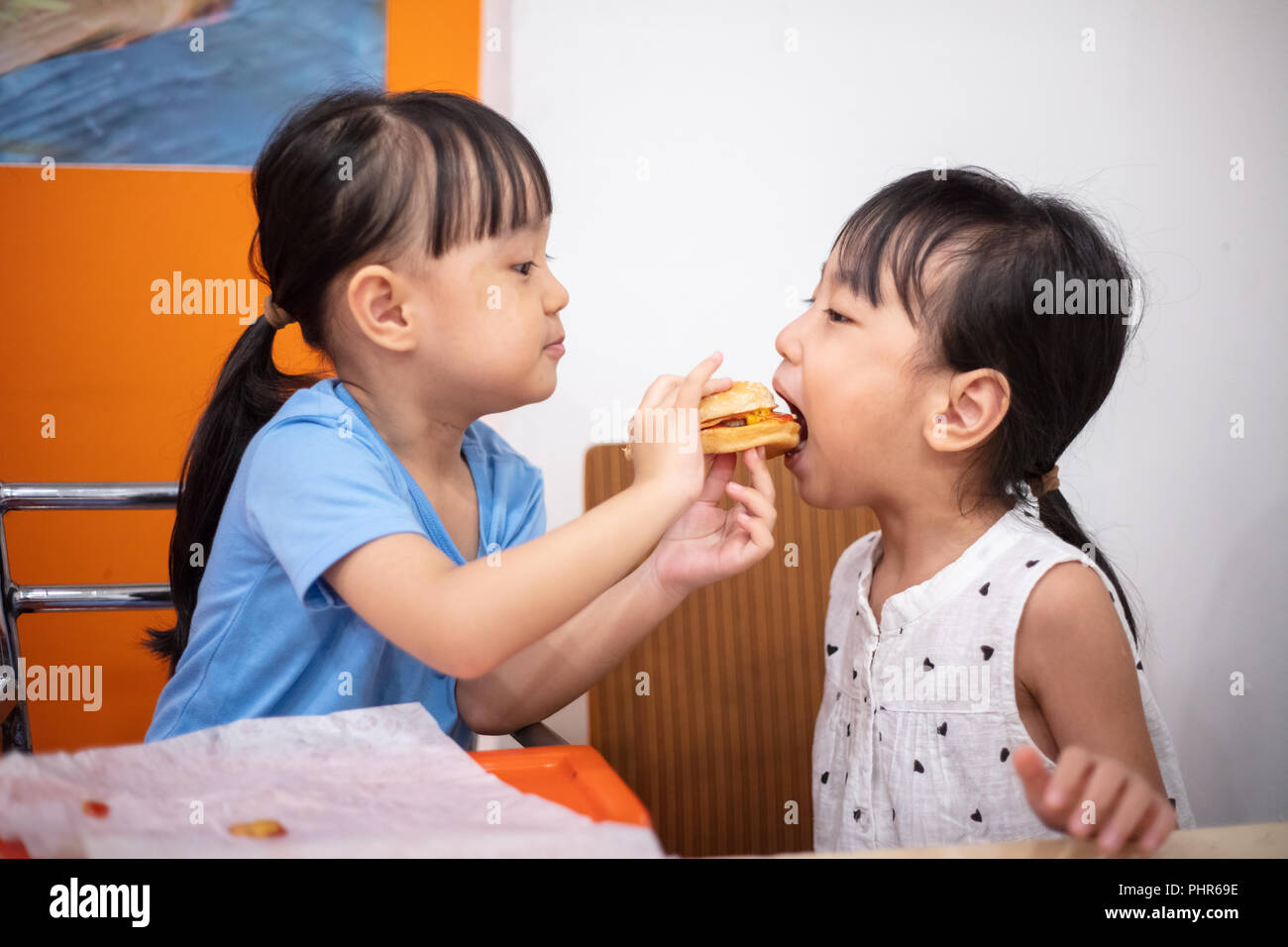 Chinois asiatique petites sœurs burger manger au restaurant de l'intérieur Banque D'Images