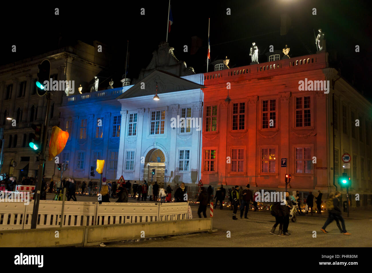 Copenhague, Danemark, 15 novembre, 2015. Des milliers de personnes à Copenhague montrent leur solidarité et sympathie avec le peuple français à l'extérieur de l'Ambassade de France à Copenhague après les attentats terroristes de vendredi dernier à Paris. L'énorme quantité de fleurs et messages pousse encore ce dimanche soir. Kongens Nytorv à Copenhague est éclairé par les couleurs du Tricolore Français projetée sur le bâtiment de l'ambassade française bondé encore après une journée de manifestations officielles et des actions spontanées de sympathie et de solidarité. Banque D'Images