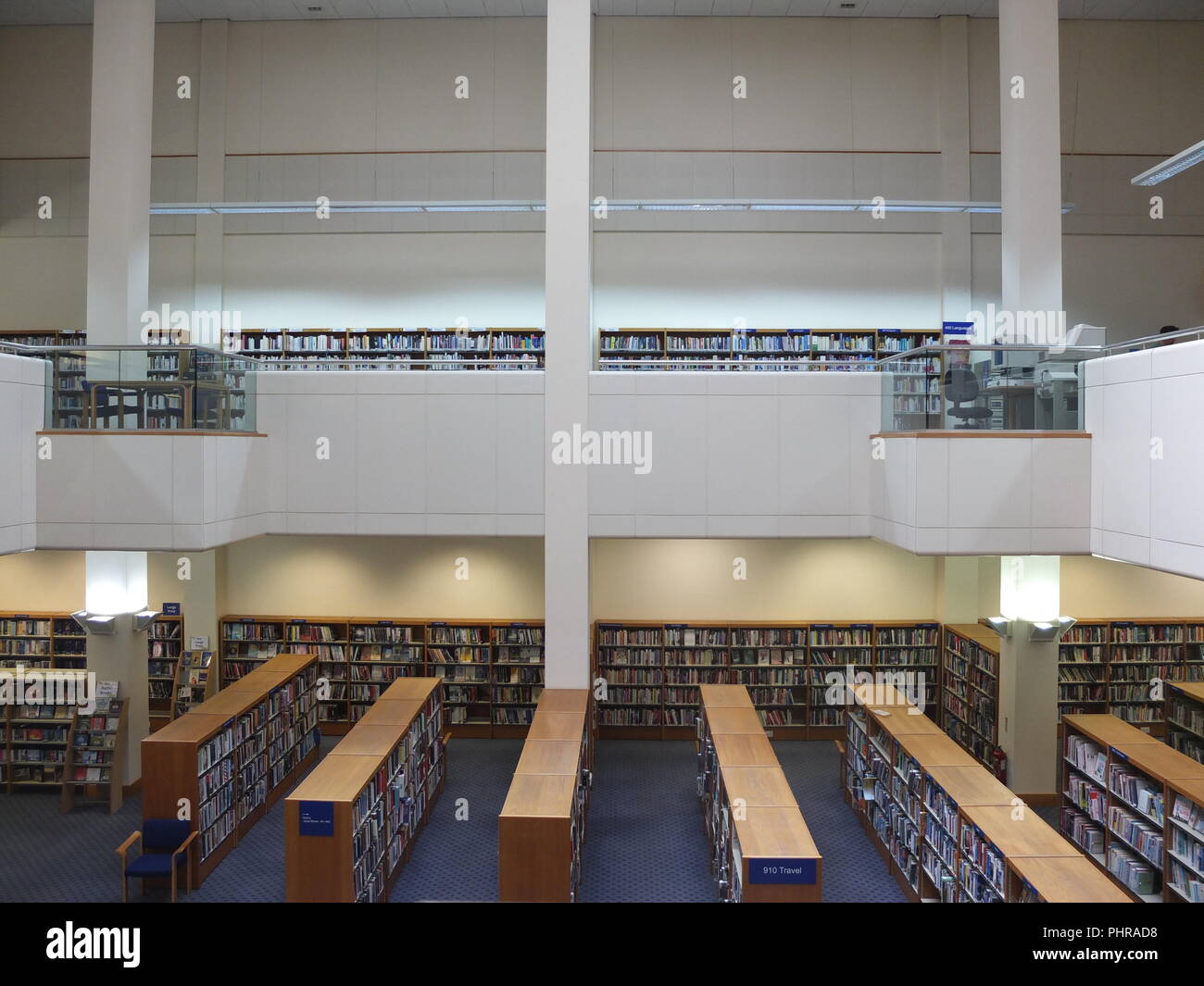 Intérieur de la Bibliothèque publique de Jersey, St Helier, Channel Islands, livres réparti sur deux niveaux sur des étagères Banque D'Images