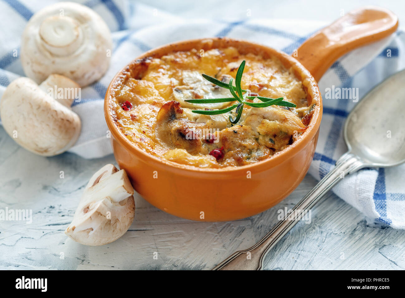 Pot en argile avec champignons sautés, poulet et fromage. Banque D'Images