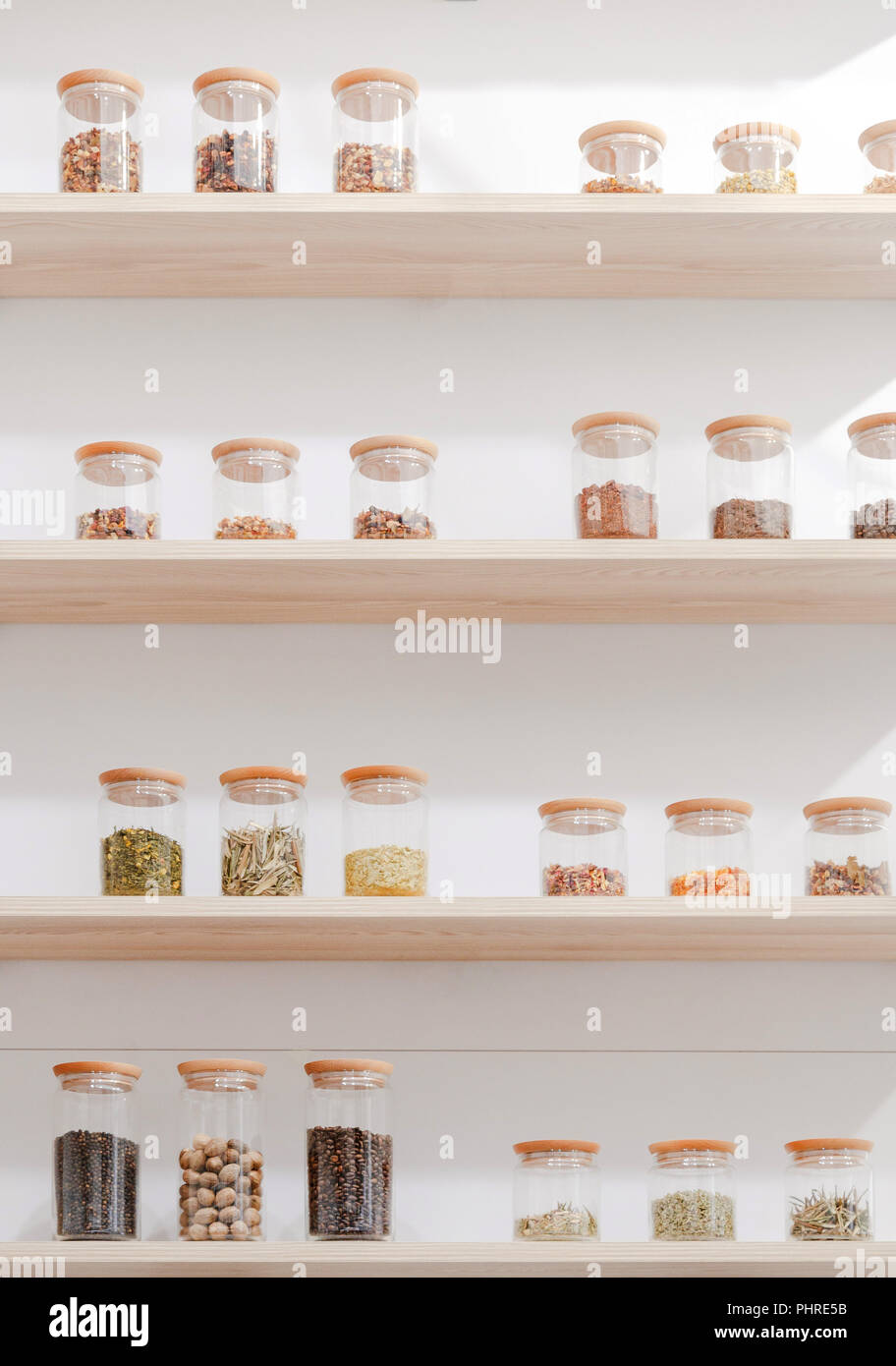Vue rapprochée de différents ingrédients dans des contenants en verre sur des étagères en bois Banque D'Images