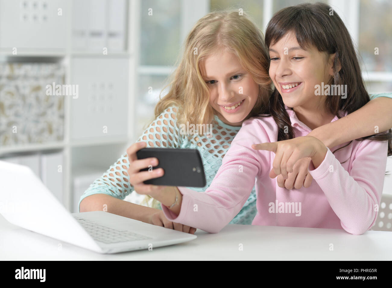 Portrait de deux jeunes filles avec téléphone et ordinateur portable Banque D'Images