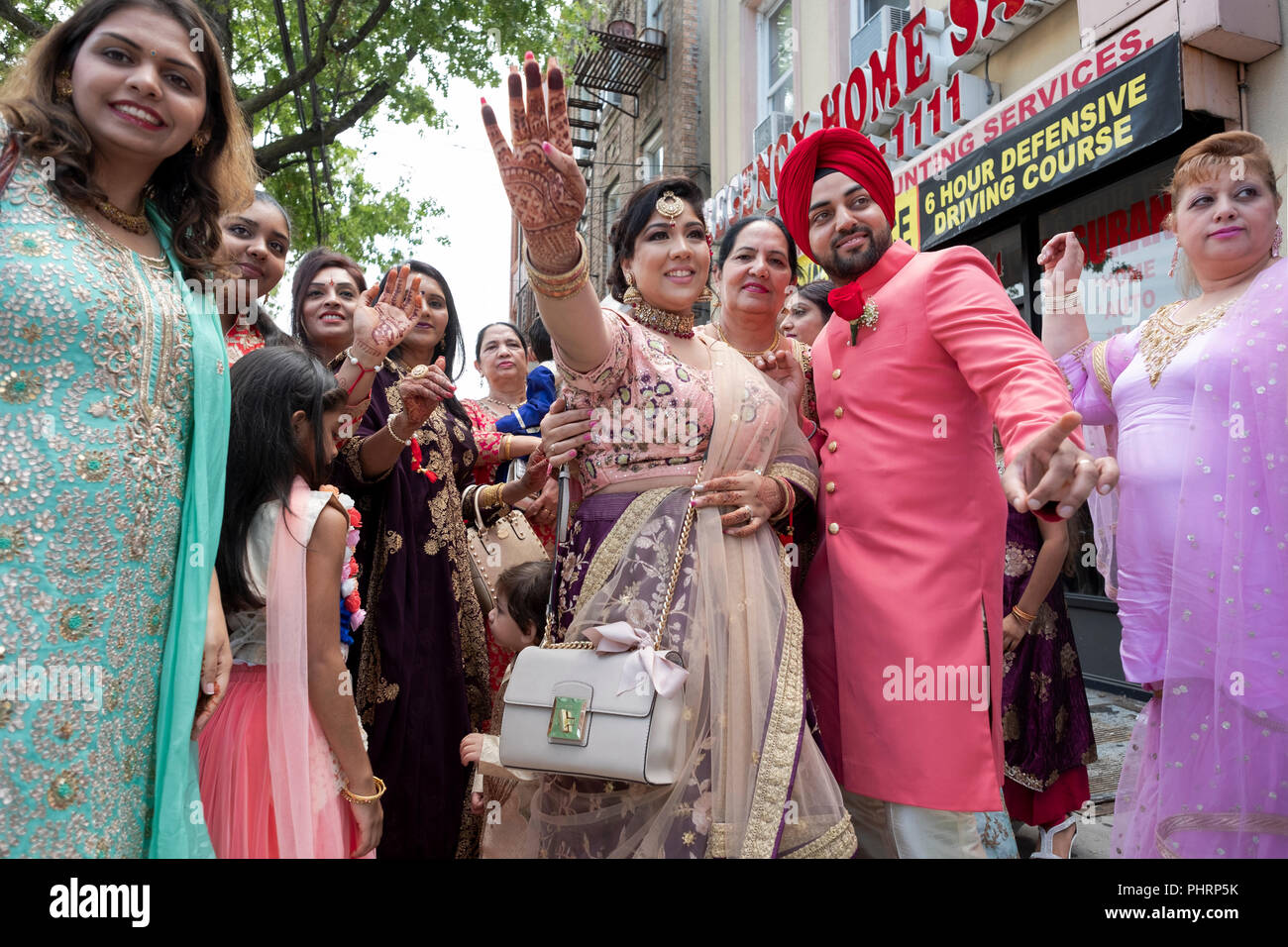 La famille et les amis d'un groom Sikh célébrer avec chants et danse avant d'escorter lui de temple pour son mariage. Dans le Queens, New York. Banque D'Images