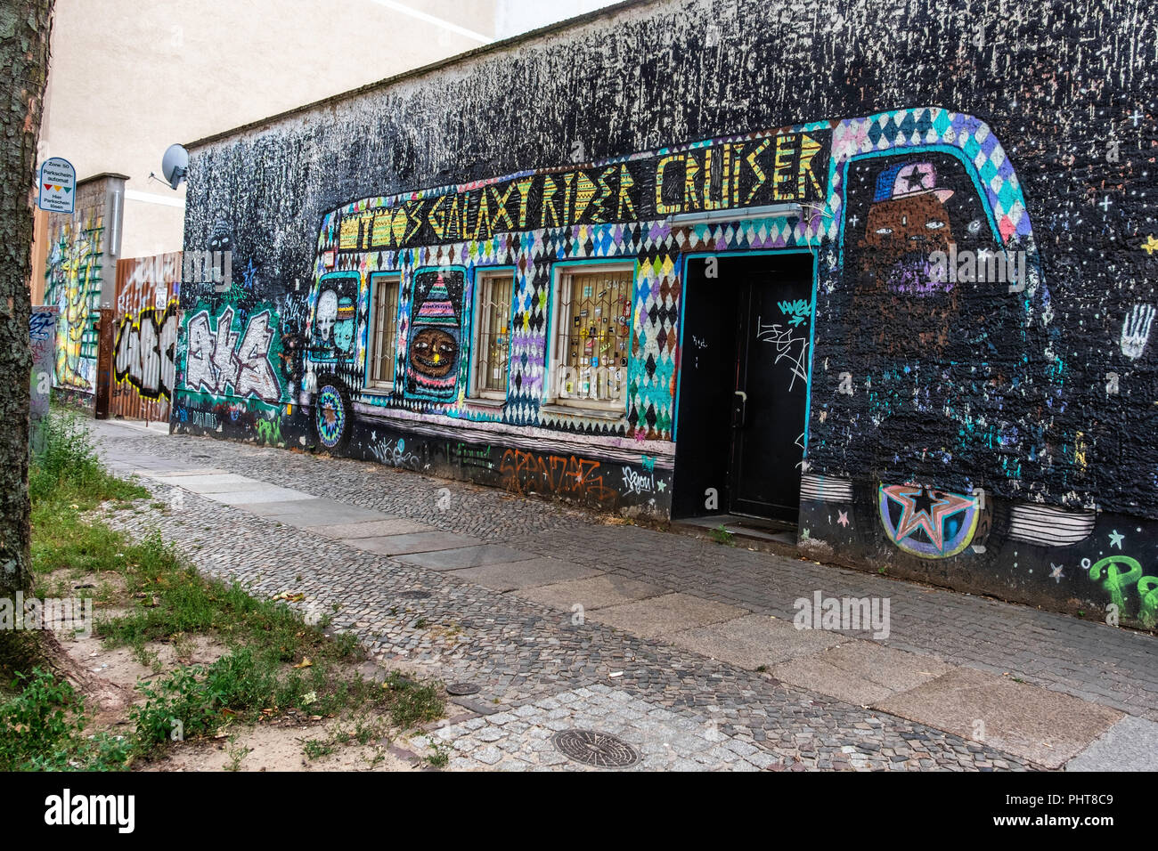 Berlin-Friederichshain.Carsystem Daniel Voss, utilisé à un concessionnaire. Mur extérieur de l'entreprise est couvert dans l'art de rue colorés Banque D'Images