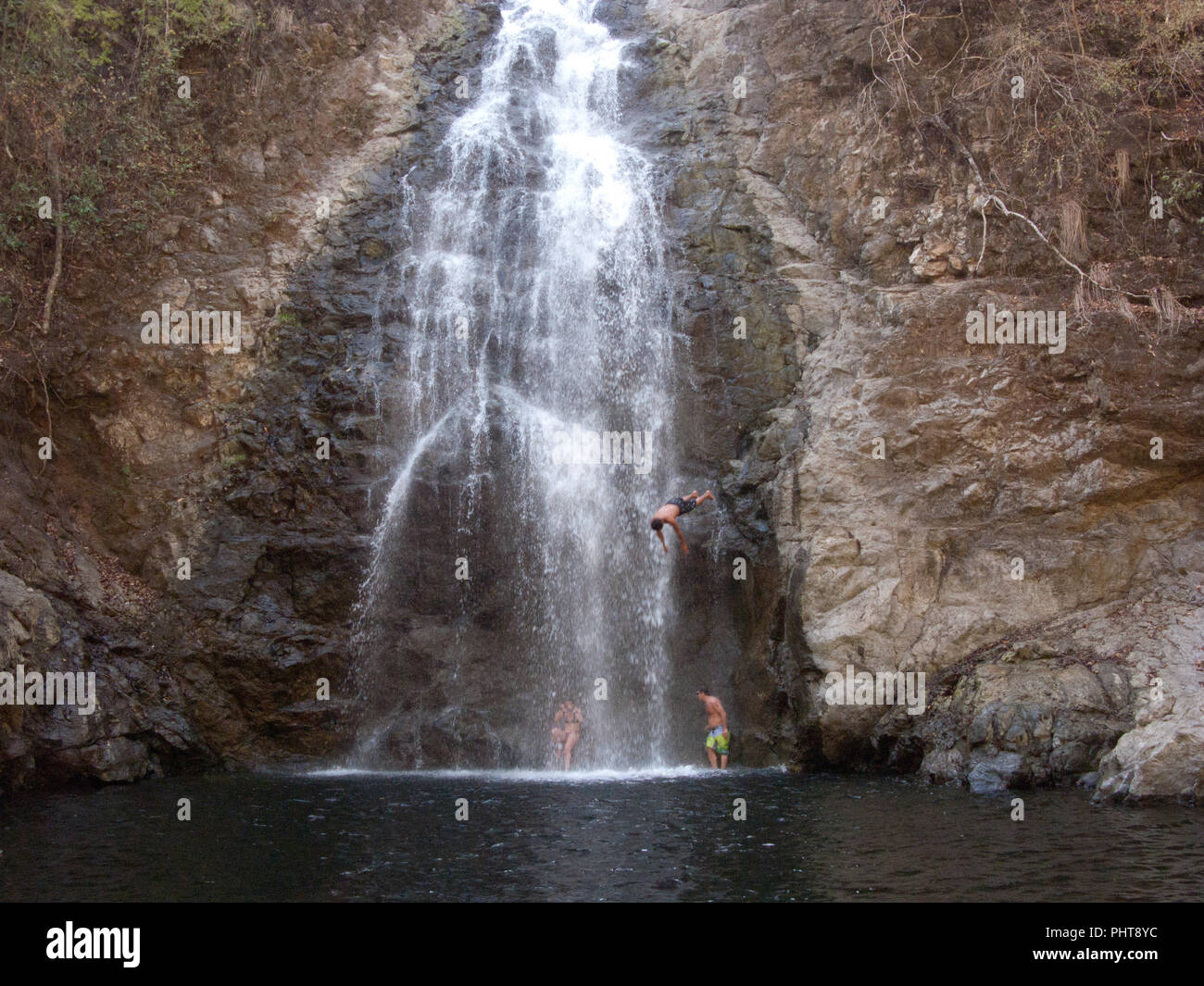 Enfants en train de sauter dans une chute dans Montezuma, Costa Rica Banque D'Images