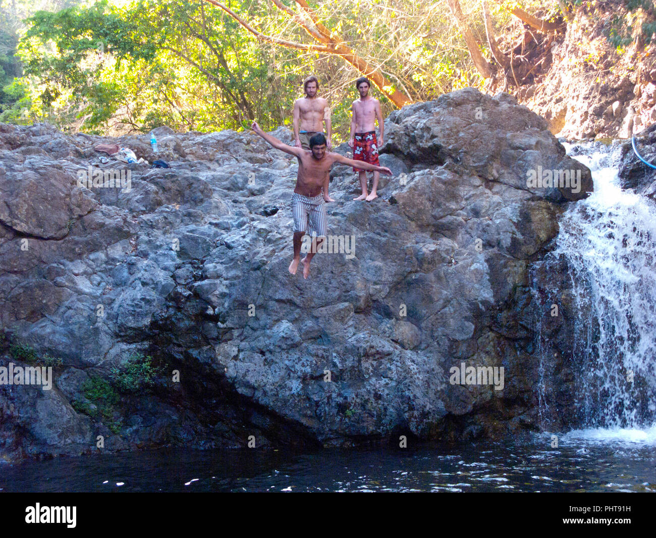Enfants en train de sauter dans une chute dans Montezuma, Costa Rica Banque D'Images