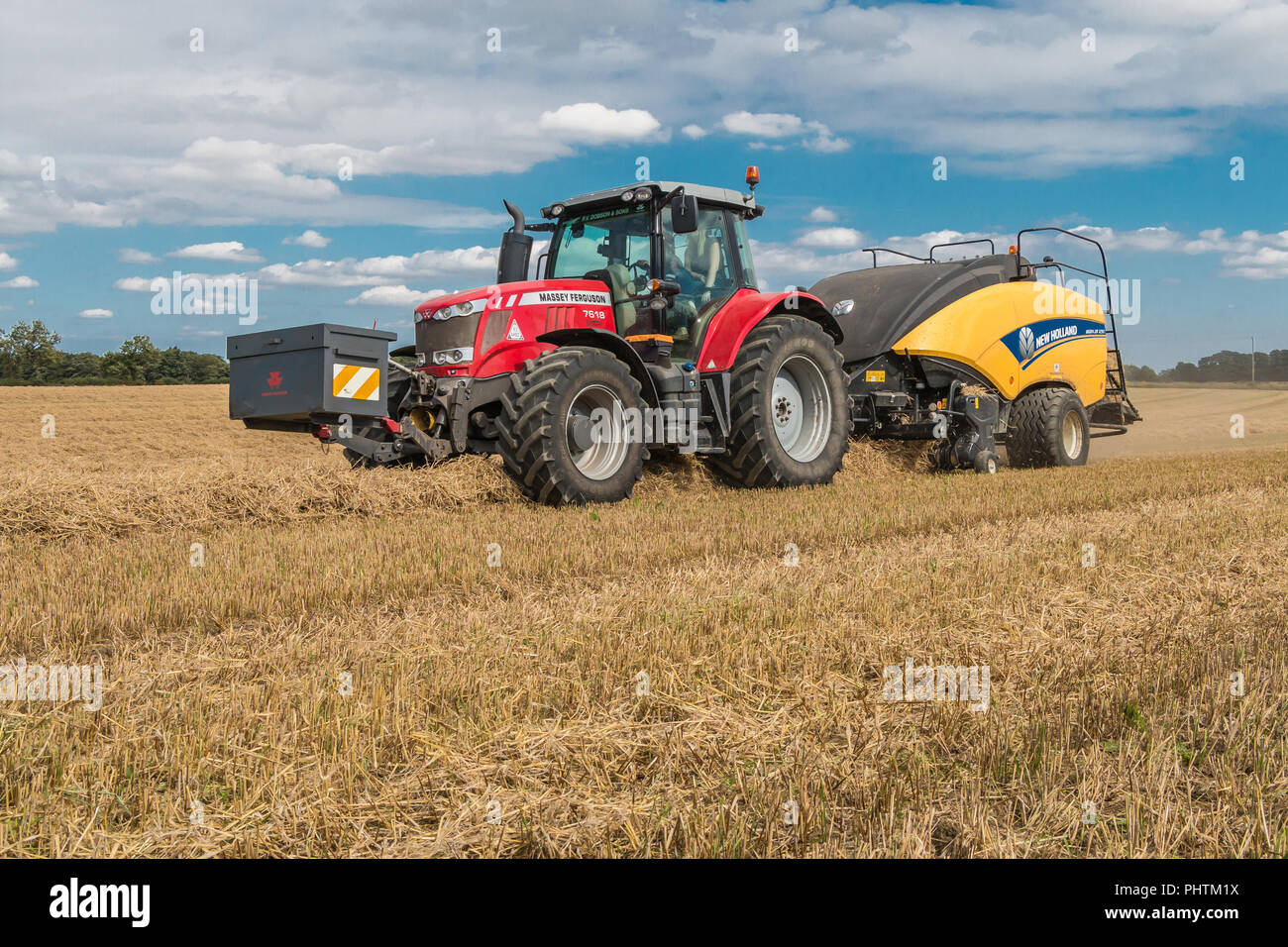 Un tracteur Massey Ferguson 7618 et New Holland 1290 Bigbaler travaillant sur la paille d'orge Banque D'Images
