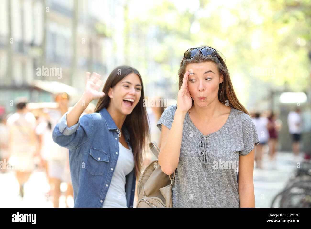 Message d'Happy teen en agitant la main et ami l'ignorant dans la rue Banque D'Images