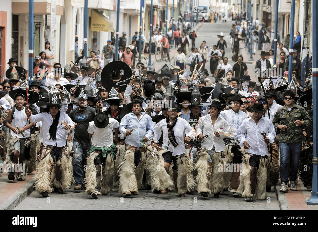 Les hommes autochtones de communautés voisines en mars dans les rues pendant les fêtes de l'Inti Raymi à Cotacachi (Équateur) Banque D'Images