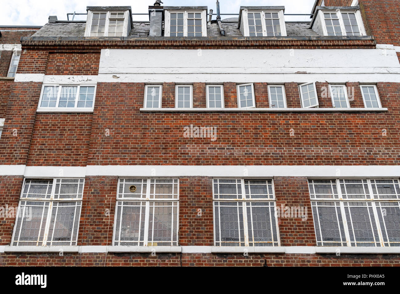 À la recherche jusqu'au grand bâtiment en briques rouges avec plusieurs fenêtres Banque D'Images
