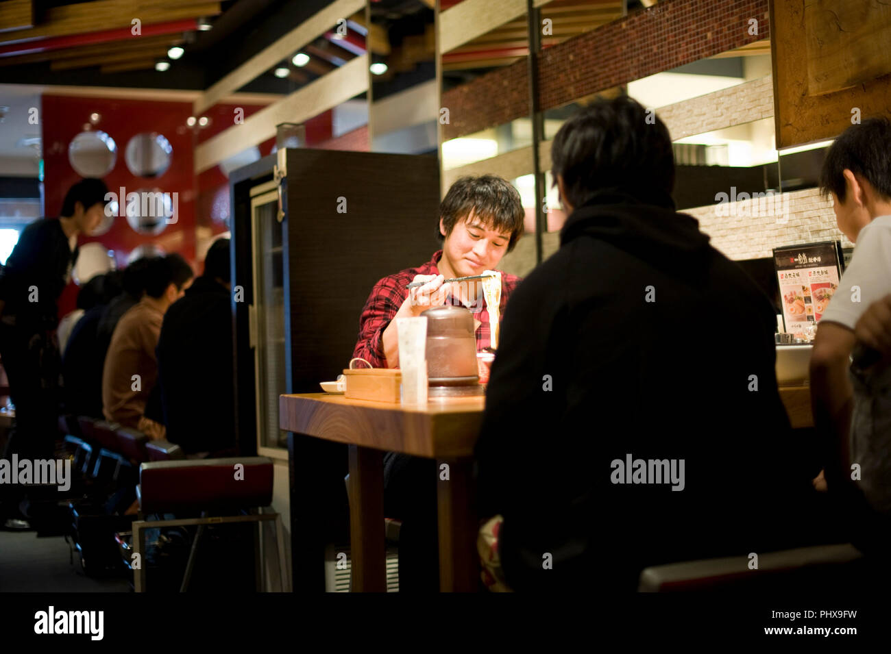 Les clients bénéficient de la soupe nouilles préparées à Hakata Ramen Ippudo dans le magasin principal du daimyo du district de Fukuoka, la Préfecture de Fukuoka au Japon, le 08 mars Banque D'Images