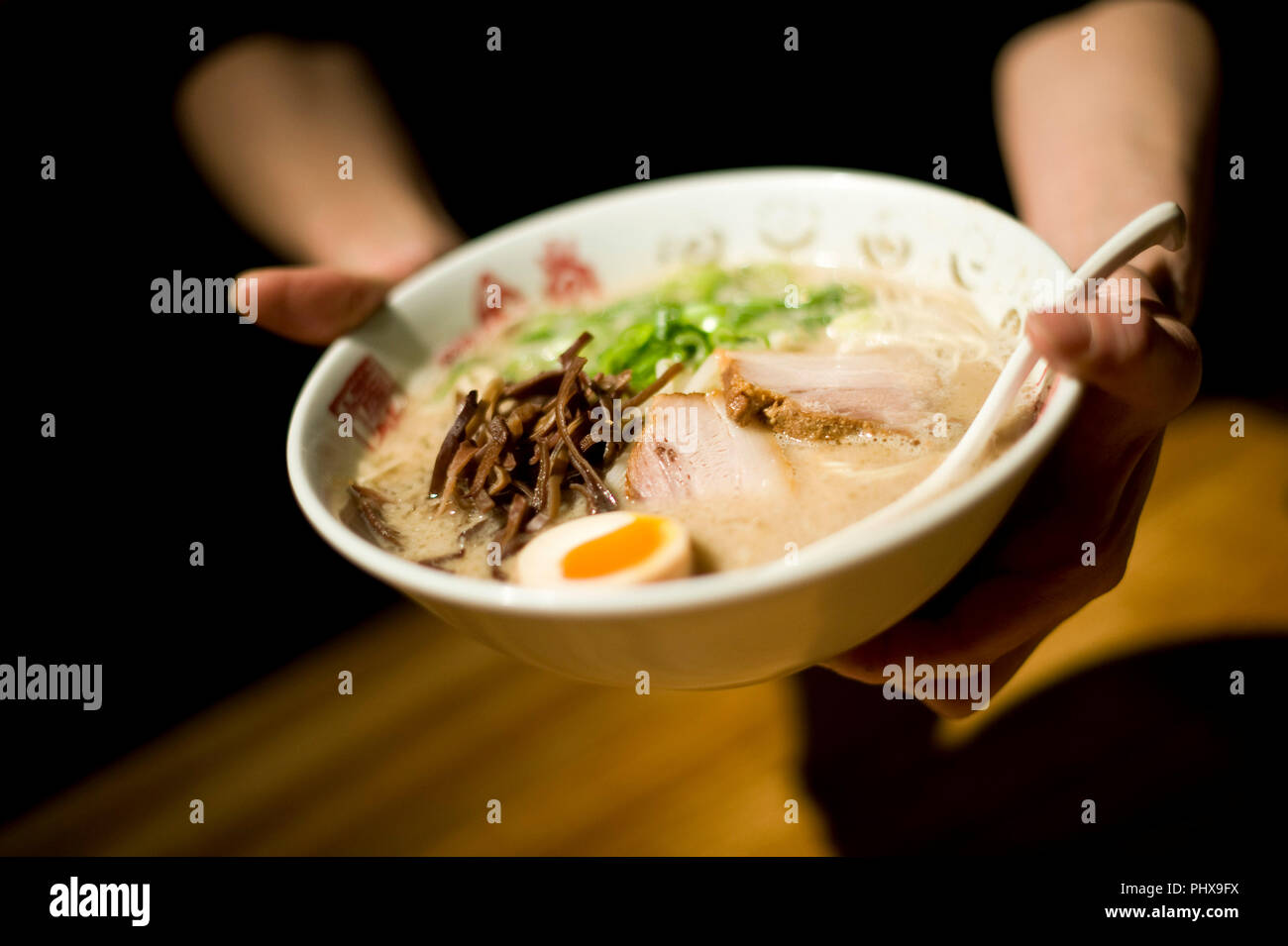 Un employé sert des nouilles préparées à Hakata Ramen Ippudo dans le magasin principal du daimyo du district de Fukuoka, la Préfecture de Fukuoka au Japon, le 08 mars 201 Banque D'Images