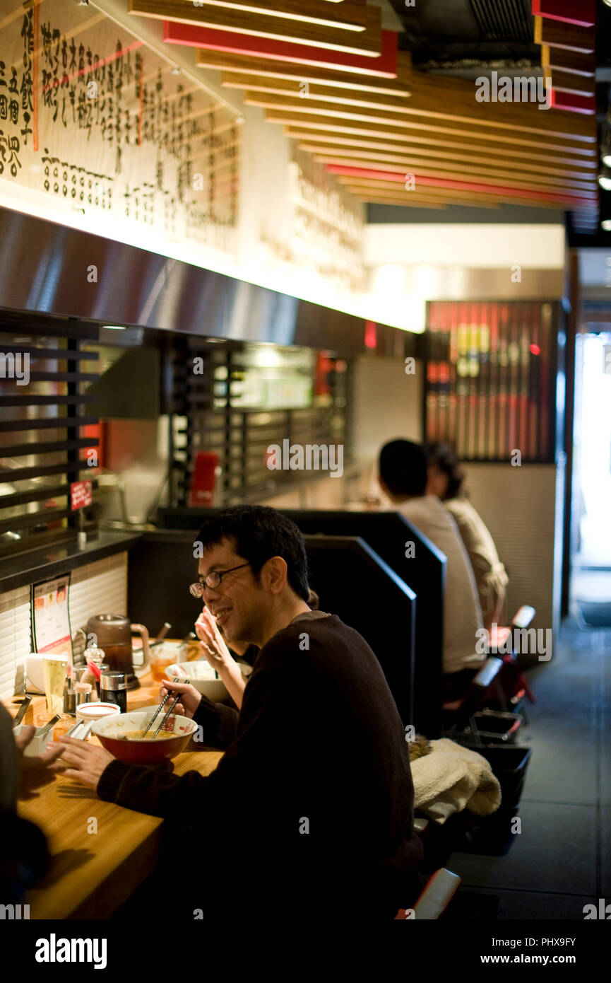 Les clients bénéficient de la soupe nouilles préparées à Hakata Ramen Ippudo dans le magasin principal du daimyo du district de Fukuoka, la Préfecture de Fukuoka au Japon, le 08 mars Banque D'Images