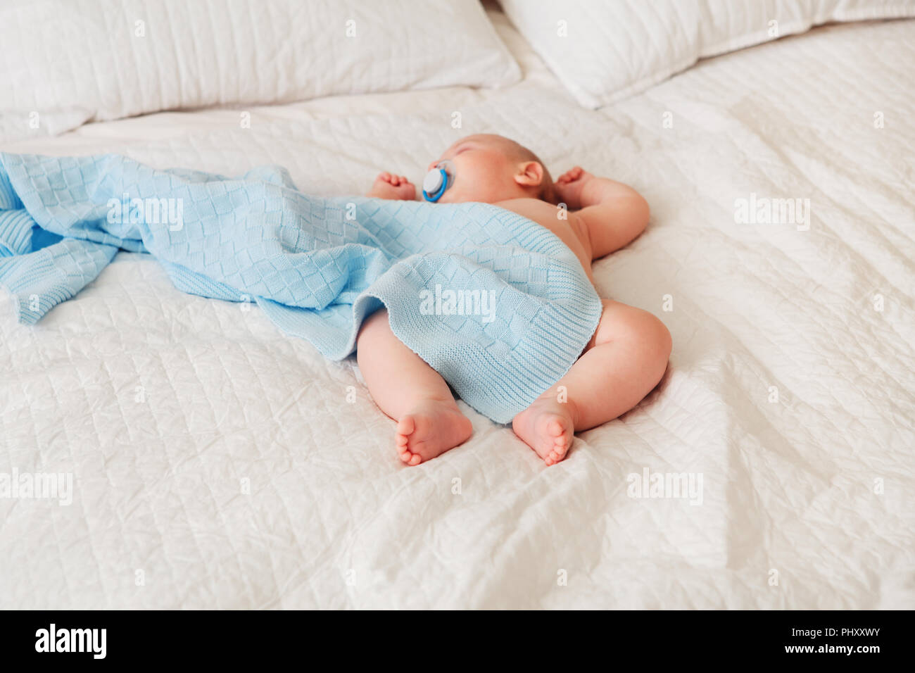 Portrait Of A Cute Adorable Bebe Nouveau Ne De Race Blanche En Couche Revant De Couchage Avec Tetine Sucette Dans La Bouche Lying On Bed Couverts De Blue Photo Stock Alamy