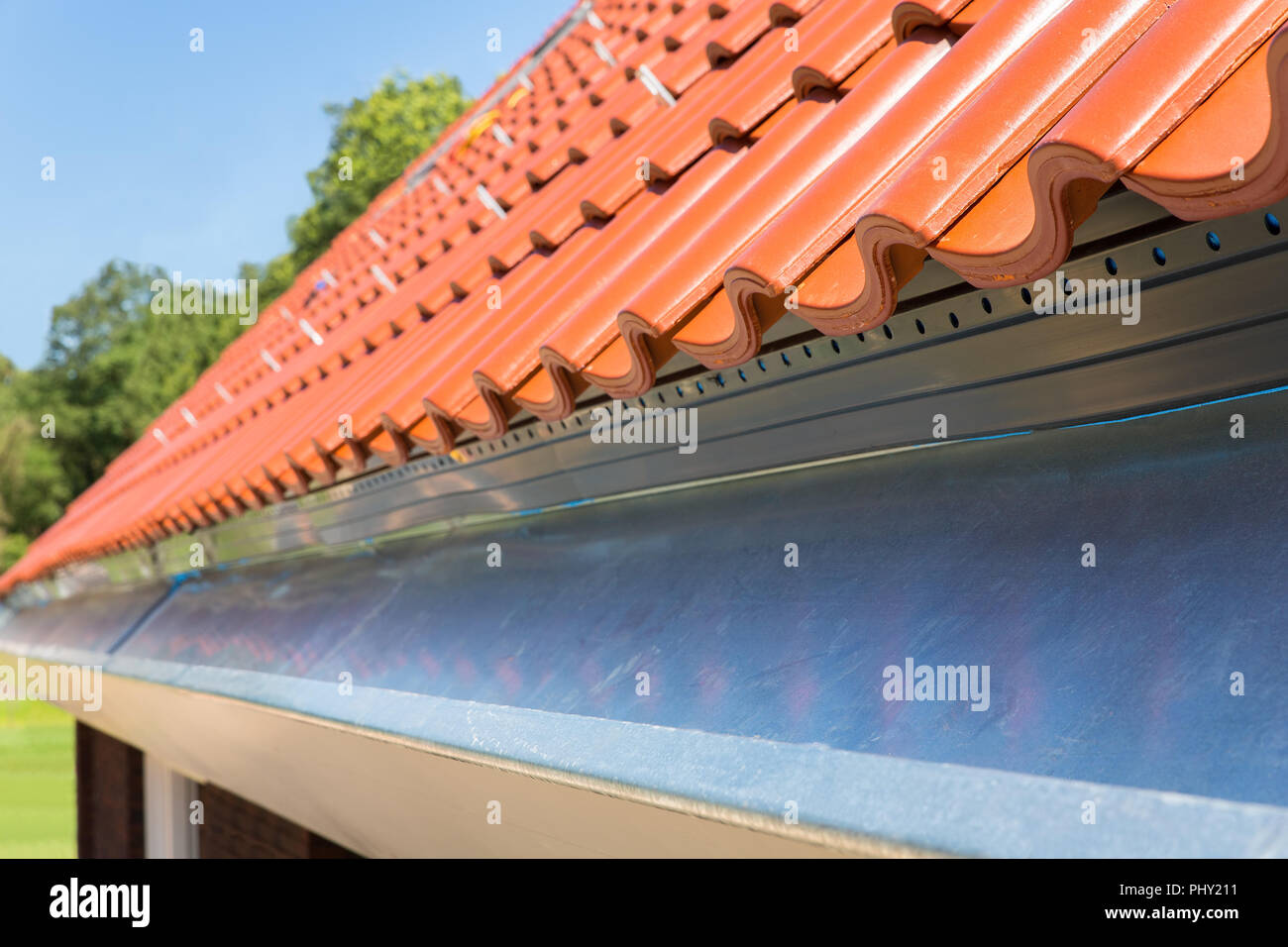 Près de nouvelles tuiles de toit avec gouttière Banque D'Images