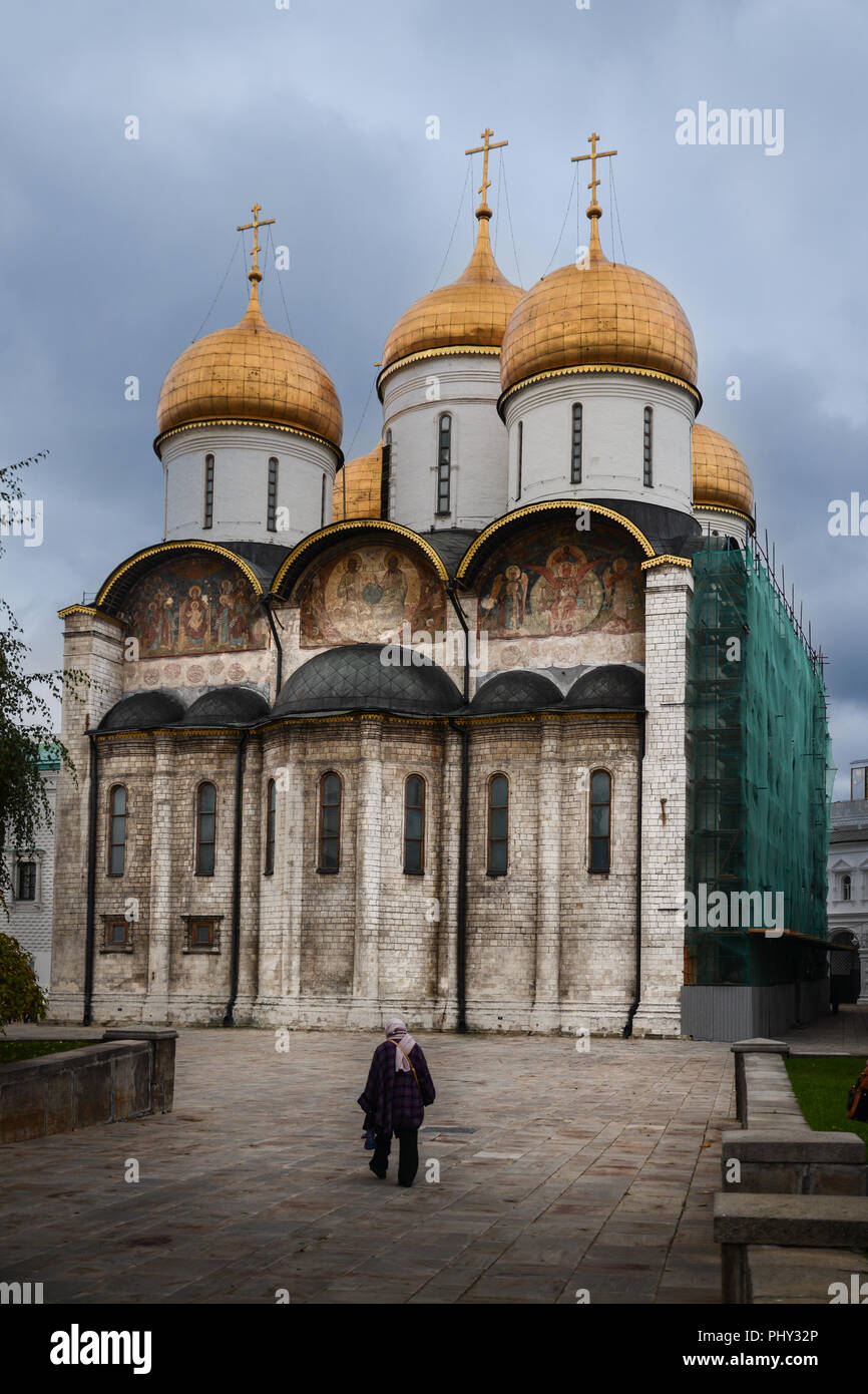 Dame âgée à marcher en direction de la cathédrale de l'Assomption avec casque d'or de dômes à Moscou, Russie Banque D'Images