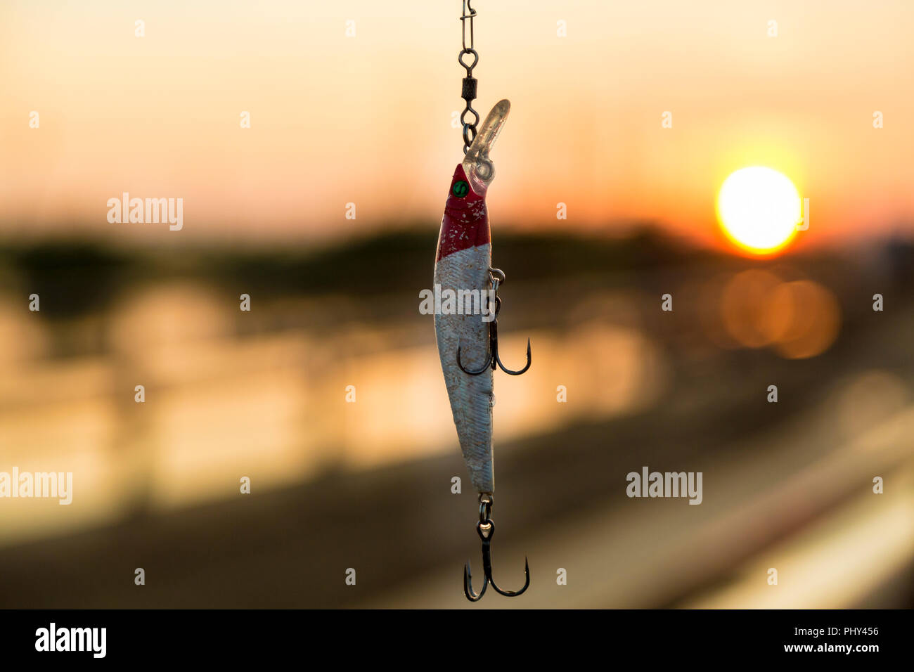 Rouge Blanc wobbler mordu avec une pique avec tees dans les rayons du soleil, avec un arrière-plan flou Banque D'Images