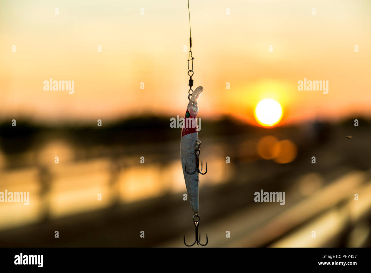 Rouge Blanc wobbler mordu avec une pique avec tees dans les rayons du soleil, avec un arrière-plan flou Banque D'Images