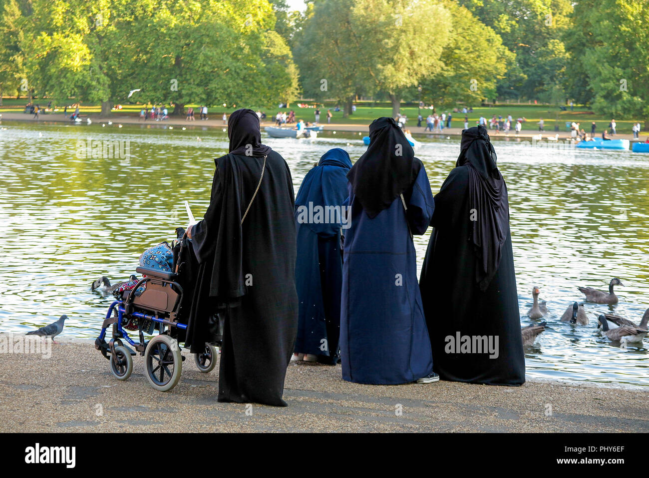 Les femmes musulmanes 4 canards d'alimentation à la Serpentine de Hyde Park Londres Banque D'Images