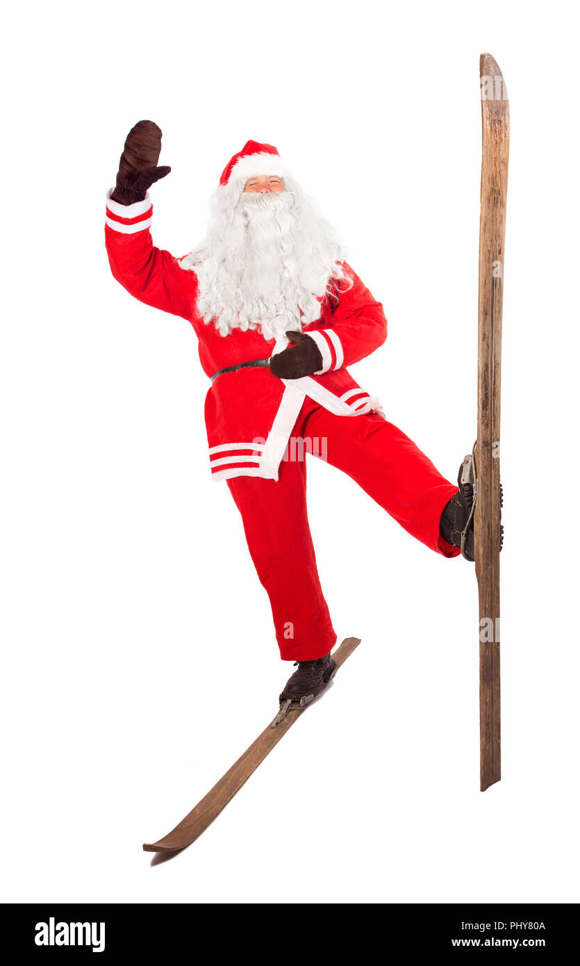 Funny Santa Claus se dresse sur un vieux rétro et ski forme avec sa main à saluer, isolé sur fond blanc. Santa sportives sur d'anciennes salutation vint Banque D'Images