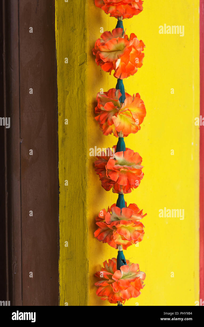 Chaîne de fleurs artificielles de décoration avec des fleurs rouge-orange, le style indien, pour la célébration et l'Adoration Banque D'Images