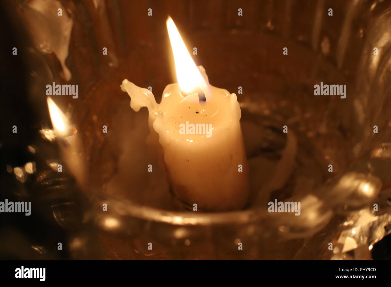 Close up de brûler bougie de cire dans un chandelier de cristal. Flamme de bougie. Noël, Nouvel An carte de souhaits, l'arrière-plan, l'église, la religion, la foi, la prière, maison de vacances, magique, twinkle, conte de fées. Banque D'Images