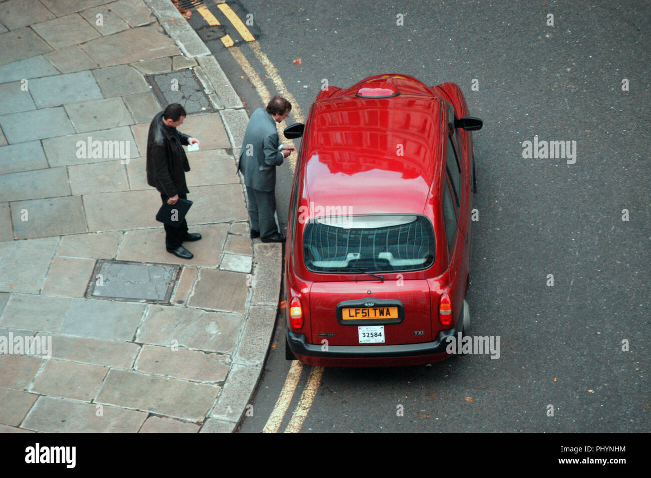 En regardant 2 passenngers entrer dans un taxi de Londres rouge très haut au-dessus Banque D'Images