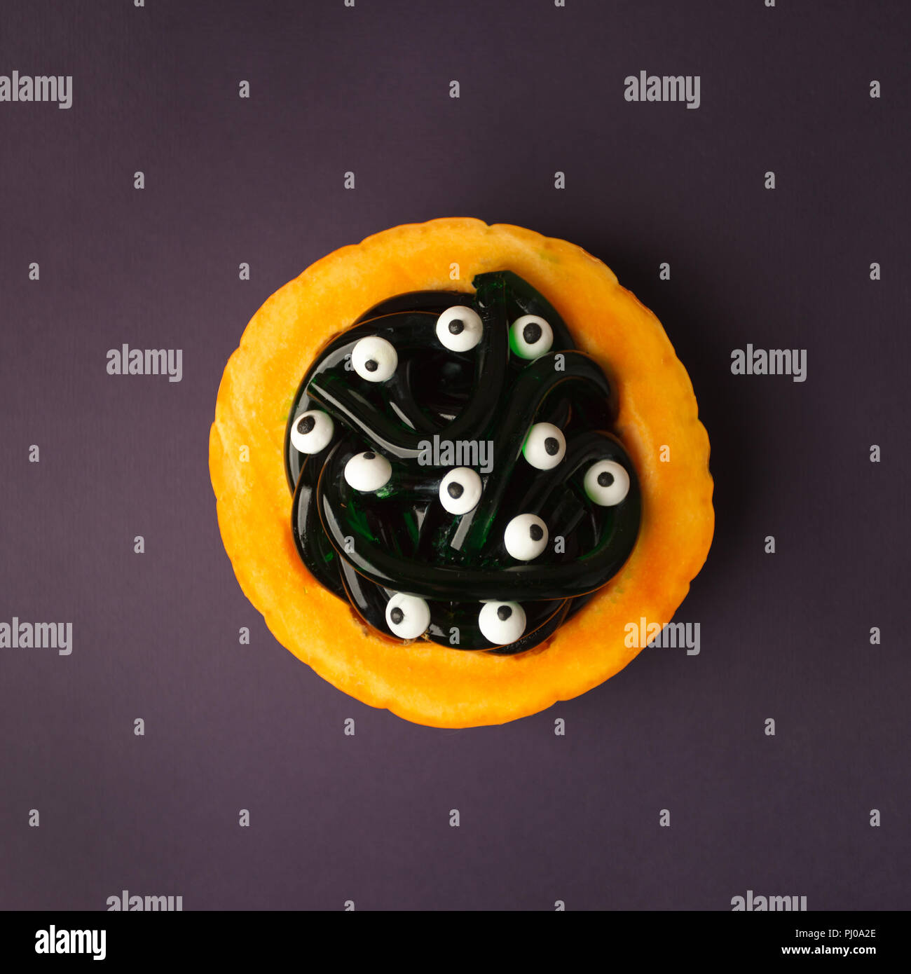 Jelly worms avec les yeux sur l'Halloween dans plaque orange citrouille. Halloween de gros plan alimentaire Banque D'Images
