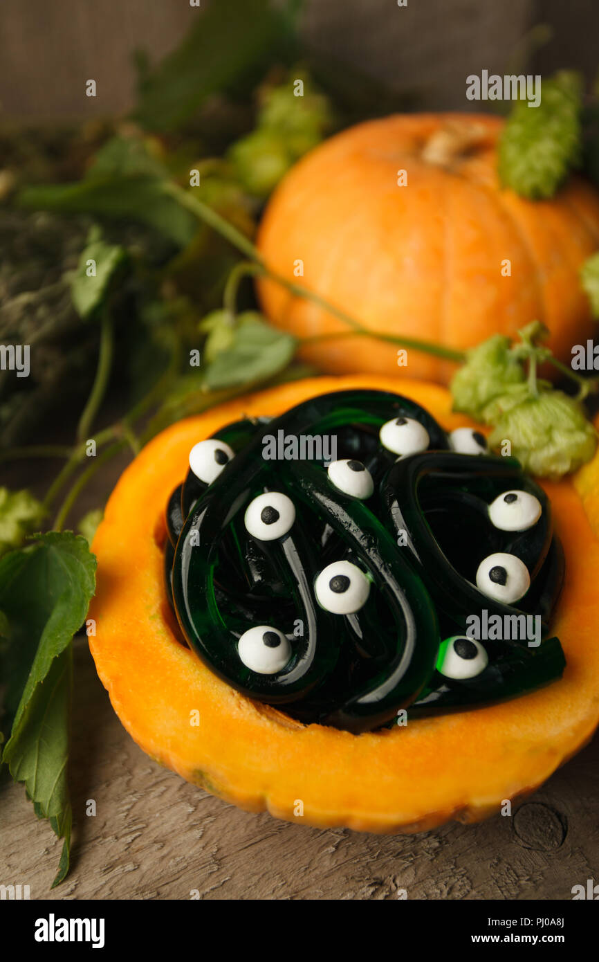 Spooky Halloween party food - gomme jelly vers dans monsret avec citrouille yeux sur fond de bois, maison de vacances partie close up Banque D'Images