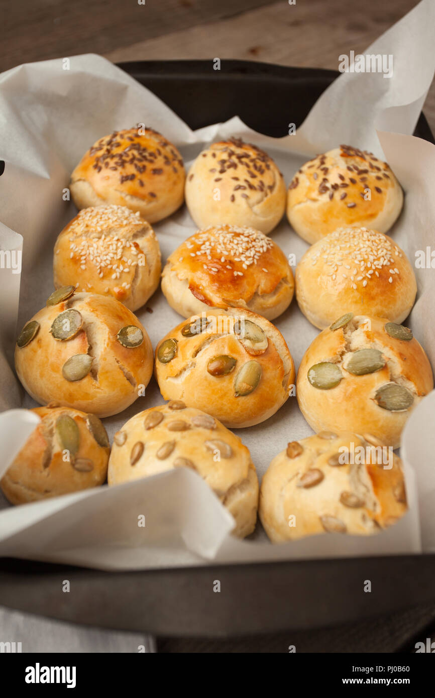 Des petits pains à hamburger, brioche avec du sésame, du potiron, de lin, graines de tournesol sur le bac, concept de burger et une cuisine maison. Mini challah Banque D'Images