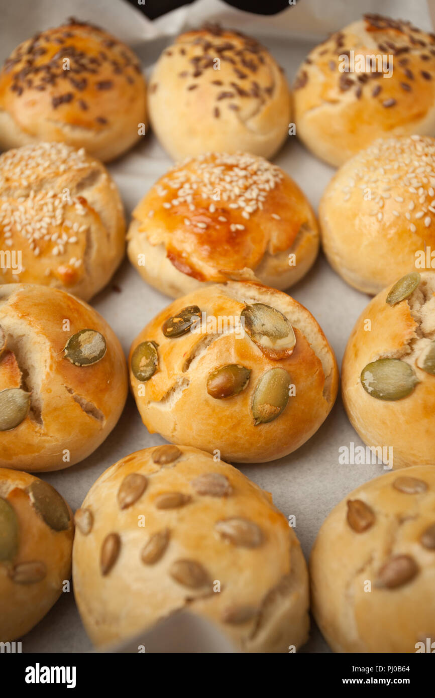 Des petits pains à hamburger, brioche avec du sésame, du potiron, de lin, graines de tournesol sur le bac, concept de burger et une cuisine maison. Mini challah Banque D'Images