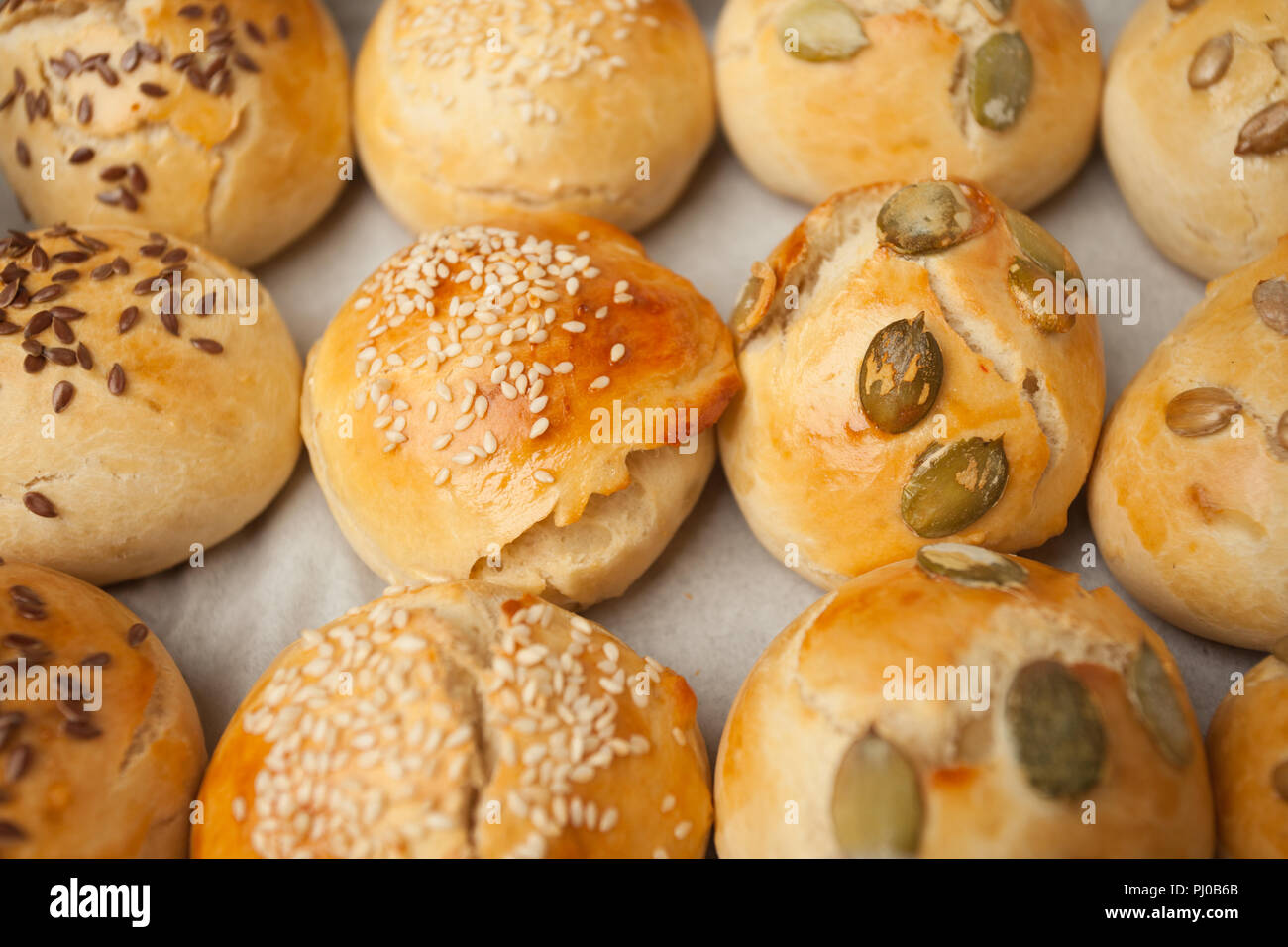 Le pain maison pains hamburger avec graines de sésame avec du sésame, la citrouille, le lin, graines de tournesol sur le bac, concept de burger et une cuisine maison. Min Banque D'Images