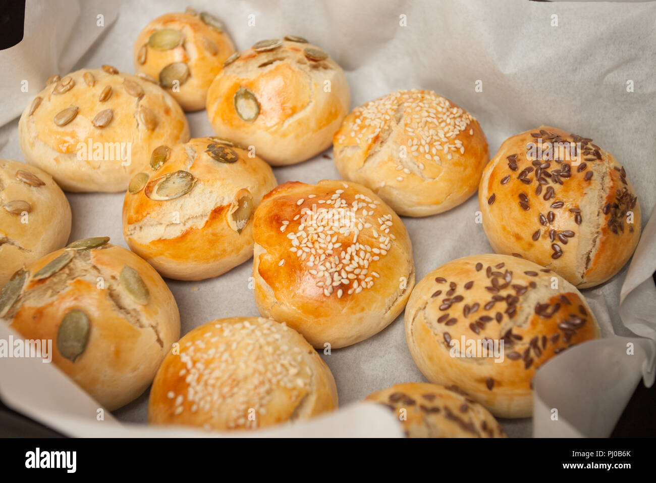Des petits pains à hamburger, brioche avec du sésame, du potiron, de lin, graines de tournesol sur le bac, concept de burger et une cuisine maison. Mini challah Banque D'Images