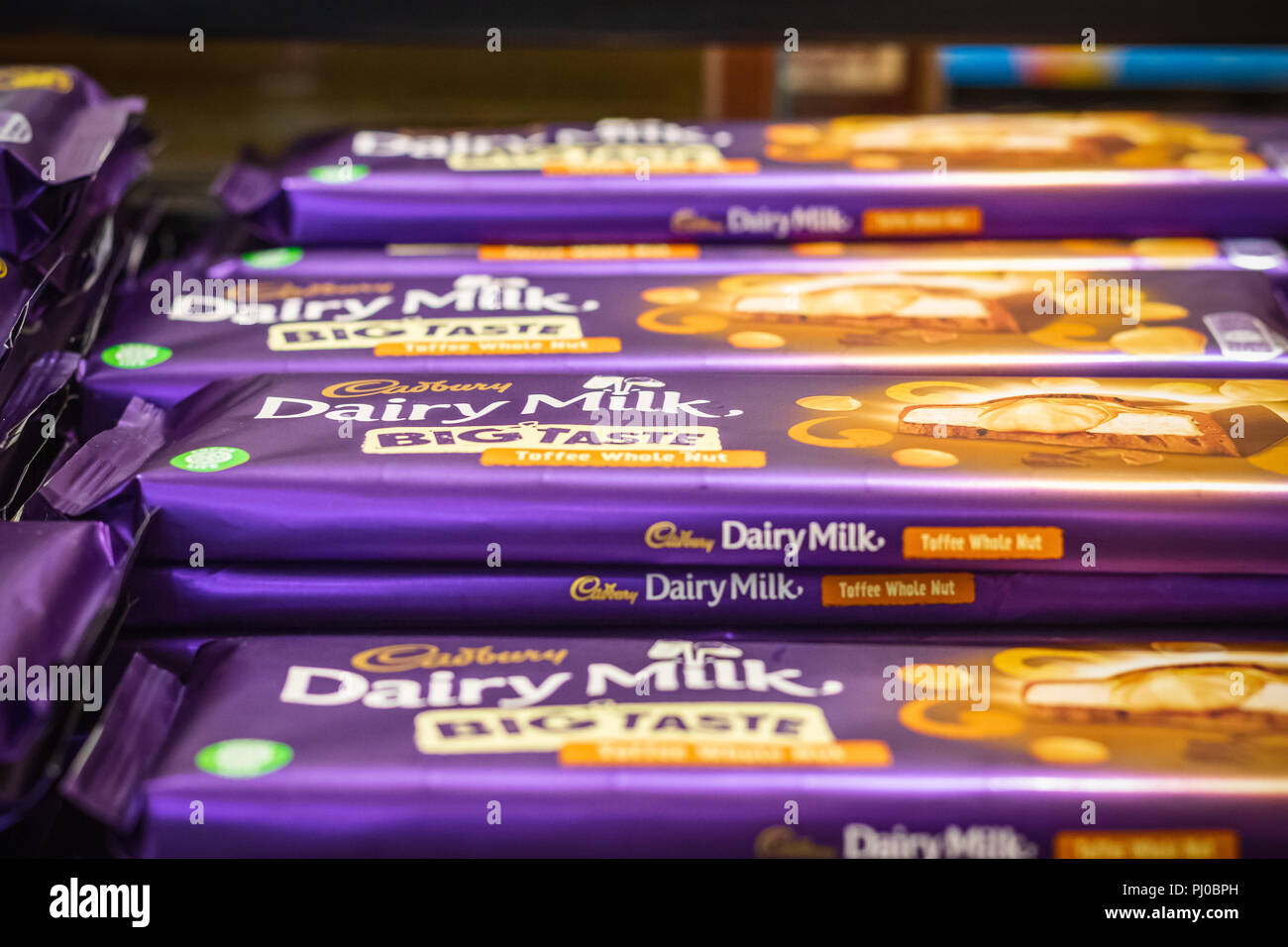 Londres, Royaume-Uni - 12 août 2018 - Pile de barres de chocolat Cadbury sur l'affichage à une boutique hors taxes à l'aéroport London Heathrow Banque D'Images