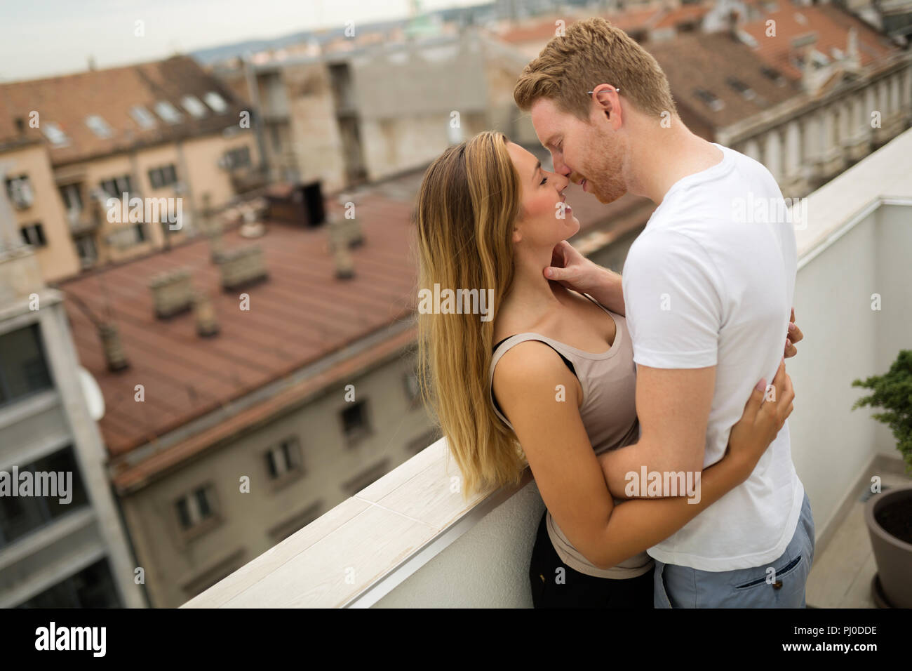 Couple kissing on rooftop Banque D'Images