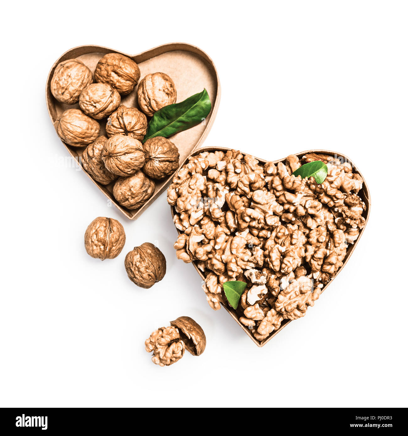 Les cerneaux de noix dans la boîte en forme de coeur, l'ensemble des noix et coquilles de l'alimentation santé et la médecine alternative, les objets concept isolated on white backgrou Banque D'Images