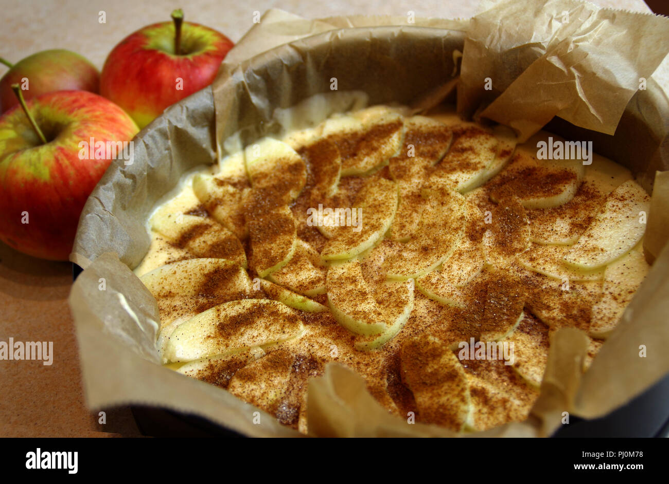 Gâteau de pomme brut prêt pour la cuisson. Pâtisserie à la cannelle la levure préparé pour four. Banque D'Images