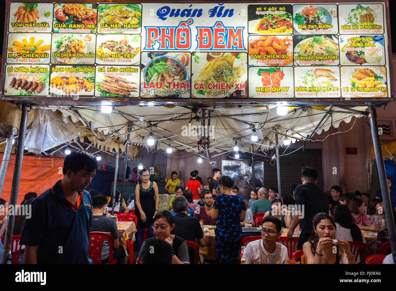 Ho Chi Minh Ville, Vietnam - le 28 avril 2018 : open air nuit street restaurant au marché Ben Thanh. Pancarte affiche le menu avec des photos, les noms des plats Banque D'Images