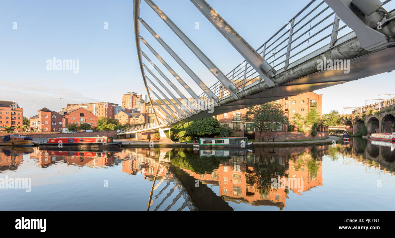 En dessous du pont du marchand sur le Canal de Bridgewater en Castelfield, Manchester, montrant un bateau amarré et des appartements Banque D'Images