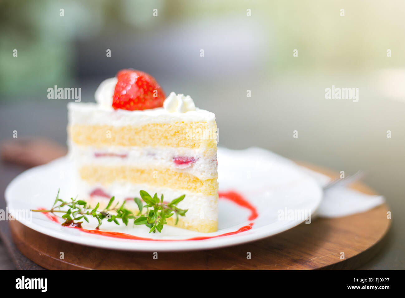 Gros plan du délicieux gâteau aux fraises faites maison avec des fruits et des feuilles sur le dessus de table boulangerie sur fond flou avec copie espace dans la nature, concept de cafe Banque D'Images