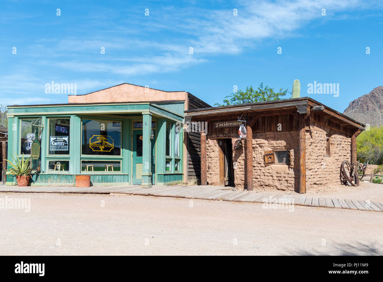 Vieux bois de l'ouest (vert) et les bâtiments d'adobe côte à côte sous un ciel bleu. Banque D'Images