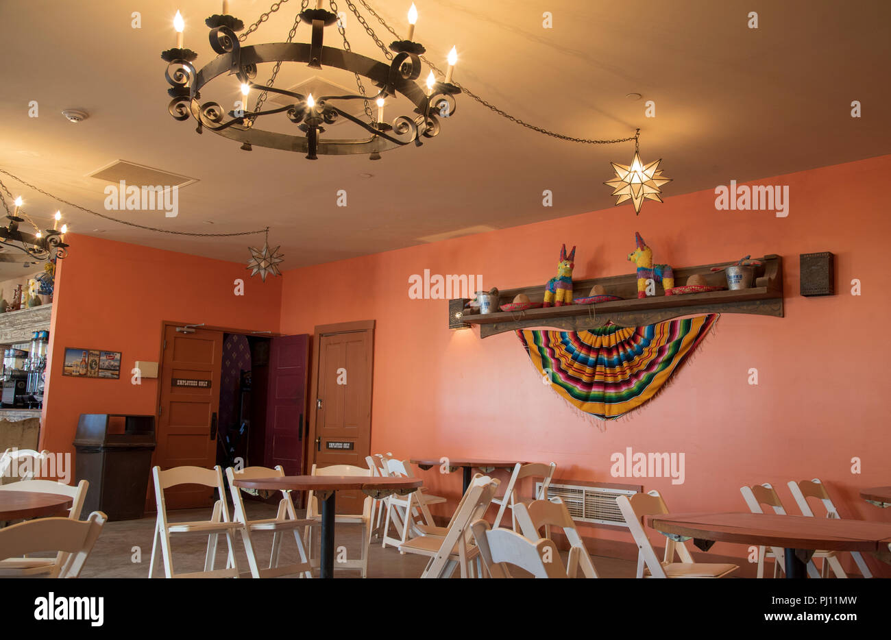 Intérieur du restaurant et bar avec chaises pliantes et mur ouest afficher, vieux style bougie Luminaire de plafond. Banque D'Images