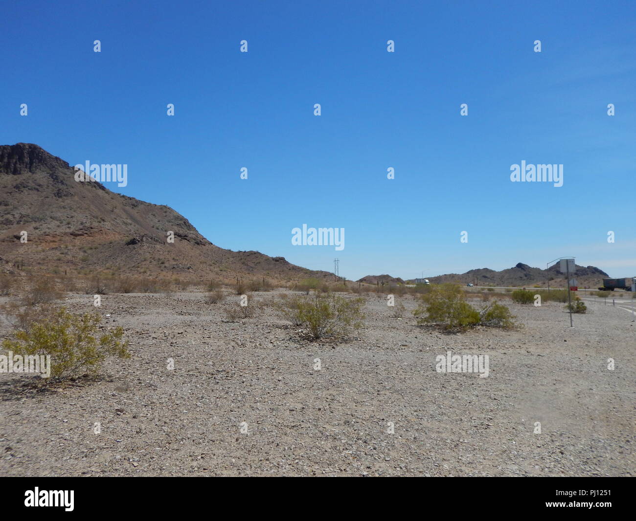 La vallée du désert avec montagnes stériles sous un ciel bleu. Banque D'Images