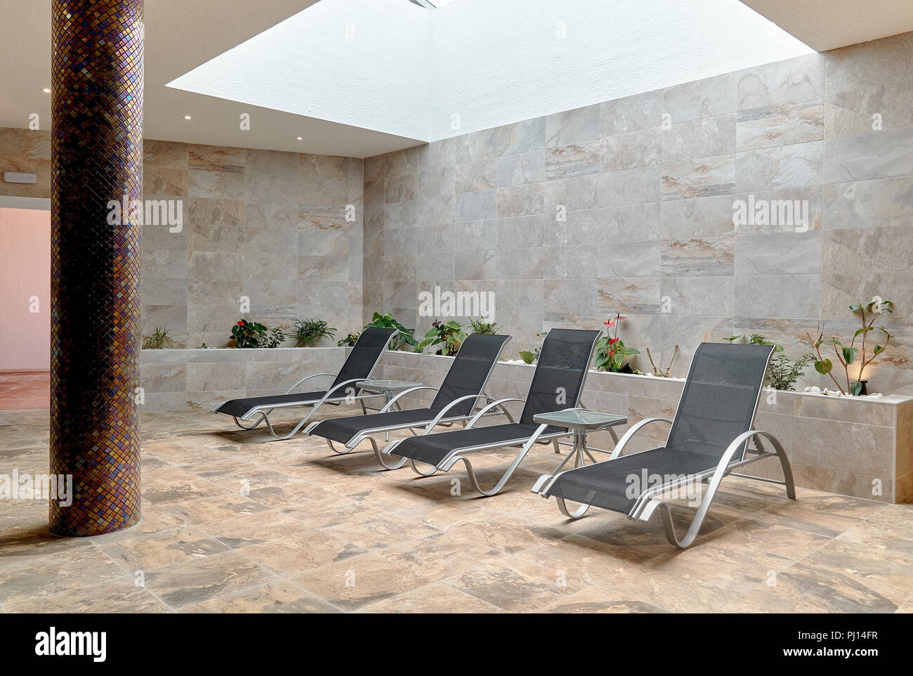 Quatre fauteuils gris vide à l'intérieur de pièce dallée. Personne n'en salle de spa. Chaise de terrasse pour les clients de se détendre après les procédures spa Banque D'Images