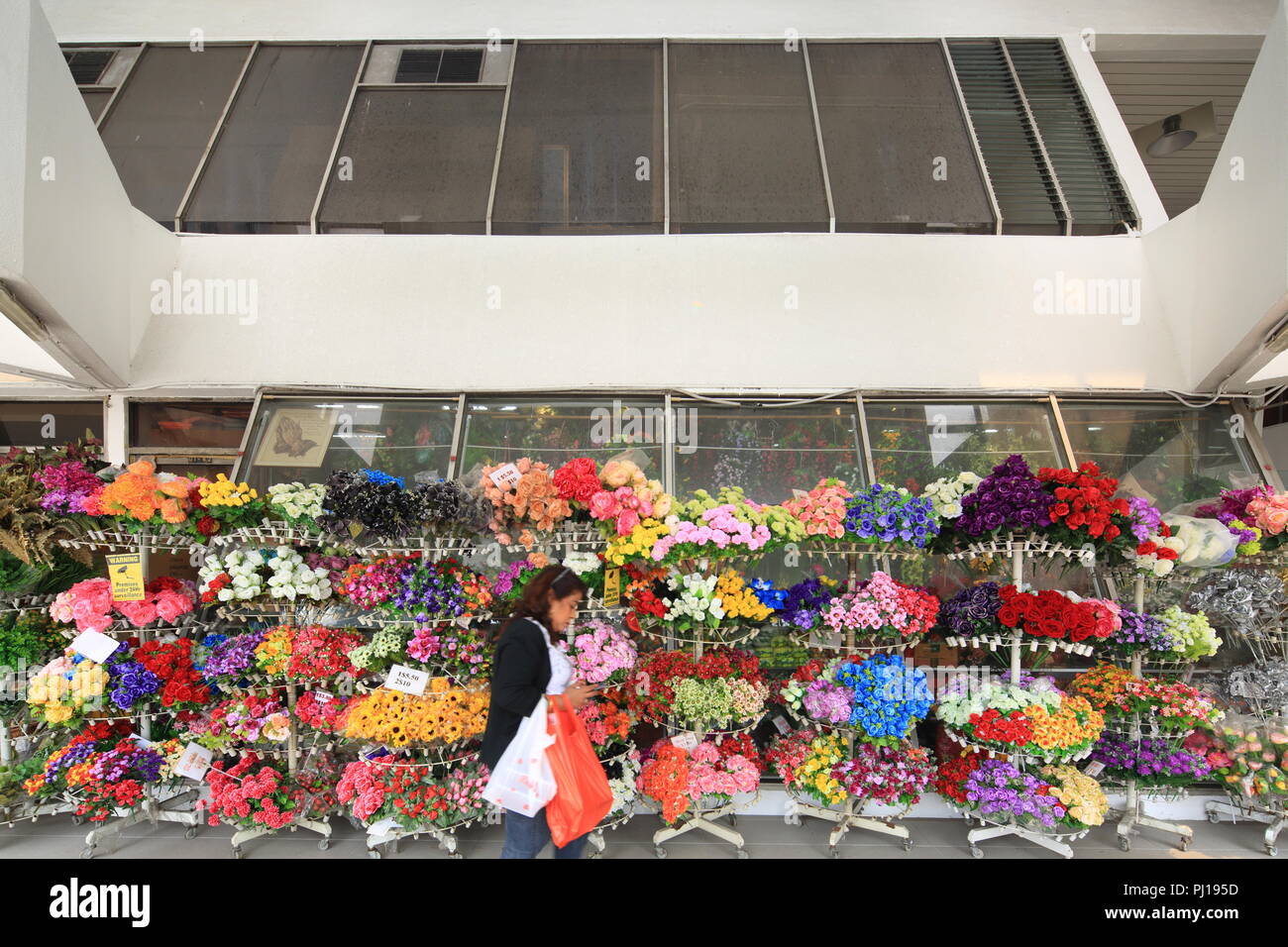 Une dame à pied passe devant une boutique florale d'affaires, Singapour Banque D'Images